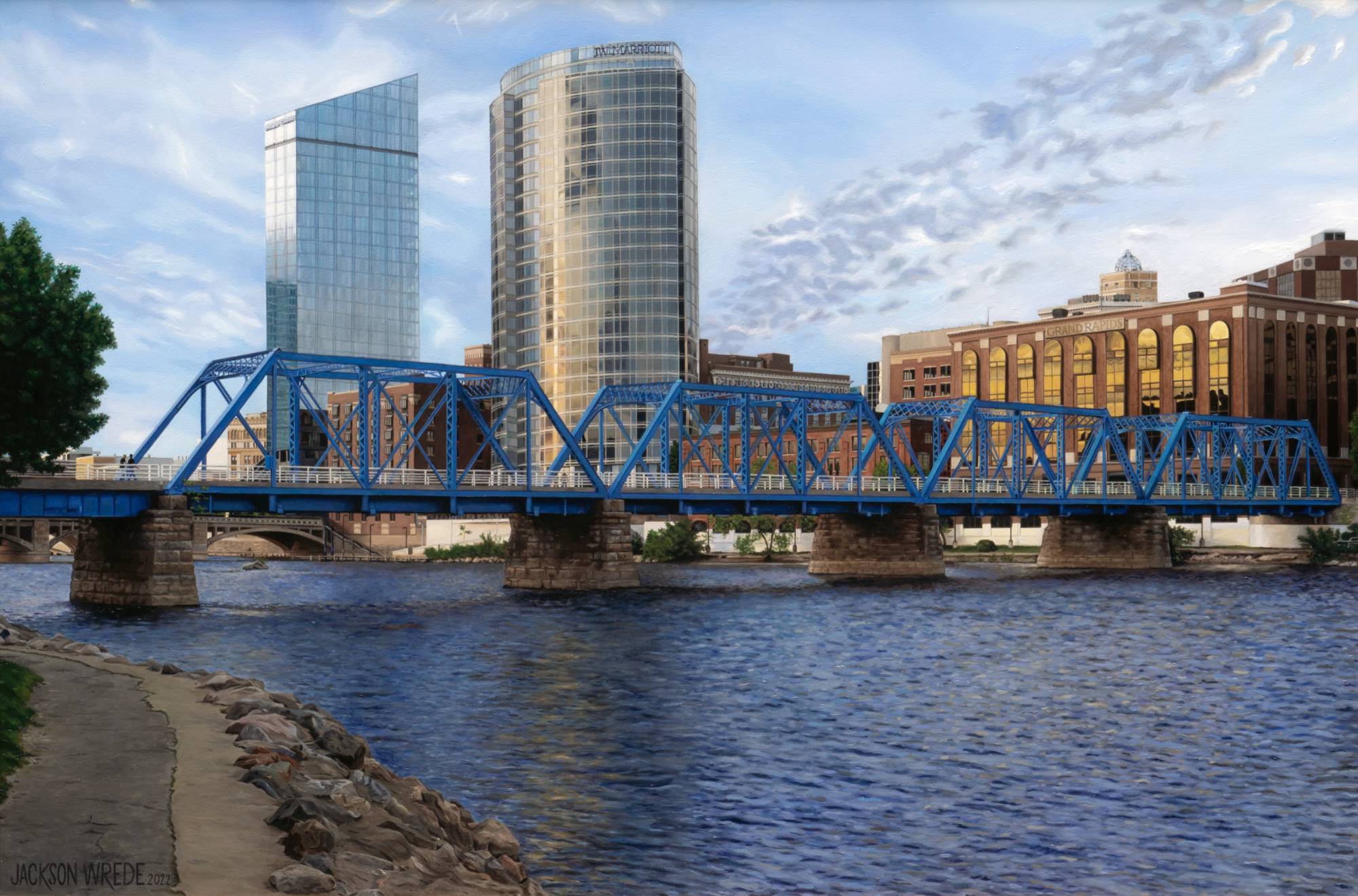 View of the blue bridge and buildings along the Grand River in a Grand Rapids Michigan cityscape.